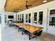 Covered patio features an elegant wood dining table and a relaxing seating area at 1690 Palm Ave, Winter Park, FL 32789