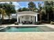 Beautiful pool area featuring a cabana, lush landscaping, and inviting lounge chairs at 1690 Palm Ave, Winter Park, FL 32789
