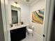 Elegant powder room featuring modern vanity, gold fixtures, and stylish abstract wall art at 1690 Palm Ave, Winter Park, FL 32789