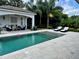 Inviting swimming pool with a cabana, lounge chairs, and lush tropical landscaping at 1690 Palm Ave, Winter Park, FL 32789
