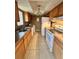 Functional kitchen features wood cabinets, white appliances, and tile flooring at 4350 Aqua Vista Dr # G, Orlando, FL 32839