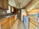 Functional kitchen features wood cabinets, white appliances, and double sinks at 4350 Aqua Vista Dr # G, Orlando, FL 32839