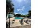 Community pool with lounge chairs and blue skies with clouds and tall palm trees at 4350 Aqua Vista Dr # G, Orlando, FL 32839