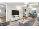 Bright living room with a modern entertainment center, plush rug, and dining area with stylish blue chairs at 4701 Goddard Ave, Orlando, FL 32804