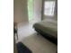 Bedroom with tile flooring featuring a bed, entry door, and barred window at 7747 Pine Hawk Ln, Orlando, FL 32822