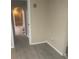Hallway with faux-wood flooring, base trim, and access to rooms at 7747 Pine Hawk Ln, Orlando, FL 32822