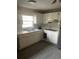 An interior view of the kitchen featuring white cabinets and a double sink under the window at 7747 Pine Hawk Ln, Orlando, FL 32822