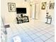 Bright living room with tile flooring, tv, and light-colored walls at 7747 Pine Hawk Ln, Orlando, FL 32822
