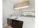 An open-concept bar area with a white countertop, dark cabinets, a mini-fridge, and a view into the living space at 8017 Chilton Dr, Orlando, FL 32836