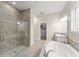 The bathroom features a shower with decorative tile and glass door, soaking tub and leads to the walk-in closet at 8017 Chilton Dr, Orlando, FL 32836