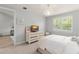 Bedroom with natural light, light gray walls, decorative chandelier and view into the living room at 8017 Chilton Dr, Orlando, FL 32836