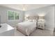 Cozy bedroom with a plush bed, elegant chandelier, and natural light from the window at 8017 Chilton Dr, Orlando, FL 32836