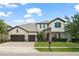 Charming two-story home with stone details, three car garage, and lush green lawn at 8017 Chilton Dr, Orlando, FL 32836