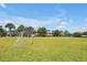 Expansive grassy field with soccer nets and a playground in the distance, ideal for outdoor activities and community events at 8017 Chilton Dr, Orlando, FL 32836