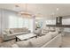 Open-concept living room with neutral tones, decorative lighting and seamless access to kitchen at 8017 Chilton Dr, Orlando, FL 32836