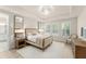 Serene main bedroom showcases tray ceiling, ample natural light, and stylish furnishings at 8017 Chilton Dr, Orlando, FL 32836
