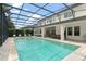 Stunning screened-in pool and spa area with travertine pavers and ample space for outdoor dining and relaxation at 8017 Chilton Dr, Orlando, FL 32836