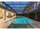 Inviting screened-in pool and spa with lush landscaping, dining, and ambient lighting at 8017 Chilton Dr, Orlando, FL 32836