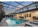 Luxurious pool area complete with a spa, outdoor dining, and lounge seating under a screened enclosure at 8017 Chilton Dr, Orlando, FL 32836