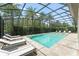 Screened-in pool area with lounge chairs and meticulous landscaping with tall trees for privacy at 8017 Chilton Dr, Orlando, FL 32836