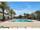 Resort-style pool with ample lounge seating and palm trees under a blue sky, perfect for relaxation and recreation at 8017 Chilton Dr, Orlando, FL 32836
