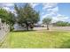 Wide backyard featuring lush green grass, mature trees, a hammock swing and a cozy fire pit at 12651 Winding Woods Ln, Orlando, FL 32832