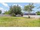Spacious backyard with white fence, healthy lawn, mature trees, and a small fire pit at 12651 Winding Woods Ln, Orlando, FL 32832