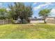 Expansive backyard featuring lush green grass, mature trees, and a cozy fire pit for outdoor enjoyment at 12651 Winding Woods Ln, Orlando, FL 32832