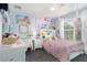 Adorable pink bedroom with a themed decor, window, desk, and carpeted floors at 12651 Winding Woods Ln, Orlando, FL 32832