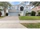 Charming two-story home featuring an arched entry, attached garage, and well-maintained landscaping at 12651 Winding Woods Ln, Orlando, FL 32832
