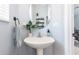 Stylish powder room with a pedestal sink, round mirror, and decorative accents at 12651 Winding Woods Ln, Orlando, FL 32832