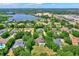 Aerial view of a luxury home nestled among lush green trees near a lake at 13710 Lake Cawood Dr, Windermere, FL 34786