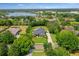 Stunning aerial view of a house with a large yard, pool, and lush landscaping near a serene lake at 13710 Lake Cawood Dr, Windermere, FL 34786