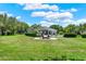 A large manicured backyard with swimming pool, outdoor kitchen, fire pit, and seating area at 13710 Lake Cawood Dr, Windermere, FL 34786