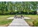 Spacious backyard with manicured lawn and a stone patio featuring a fire pit and seating at 13710 Lake Cawood Dr, Windermere, FL 34786