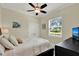 Cozy bedroom with a ceiling fan, window, and a dresser with a mounted television at 13710 Lake Cawood Dr, Windermere, FL 34786