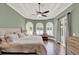 This primary bedroom features tray ceilings, large windows, and a private balcony at 13710 Lake Cawood Dr, Windermere, FL 34786