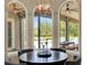 Breakfast nook featuring a round table and views of the backyard pool through arched picture windows at 13710 Lake Cawood Dr, Windermere, FL 34786