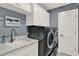 Well-equipped laundry room with front-load washer and dryer, sink, ample counter space, and bright white cabinets at 13710 Lake Cawood Dr, Windermere, FL 34786