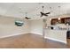 Spacious living room with hardwood floors, ceiling fans, a mounted TV, and a wet bar area at 13710 Lake Cawood Dr, Windermere, FL 34786