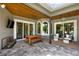 Covered patio with pavers, an outdoor dining set, comfortable seating, and a ceiling fan at 13710 Lake Cawood Dr, Windermere, FL 34786