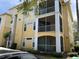 Three-story yellow building with screened-in patios and well-maintained landscaping at 1420 Lake Shadow Cir # 9207, Maitland, FL 32751