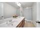 Bright bathroom featuring a double vanity, a large mirror, and a shower-tub combination with curtain at 14883 Golden Sunburst Ave, Orlando, FL 32827