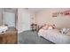 Comfortable bedroom painted in light pink featuring a cozy bed with plush pillows and a vintage school desk at 14883 Golden Sunburst Ave, Orlando, FL 32827