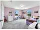 Comfortable bedroom painted in light purple featuring two windows, a desk, and a cozy bed with plush pillows at 14883 Golden Sunburst Ave, Orlando, FL 32827
