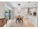Bright dining area with modern light fixture adjacent to the kitchen and sliding glass door at 14883 Golden Sunburst Ave, Orlando, FL 32827