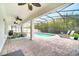 Relaxing outdoor living with screened-in pool, covered patio, ceiling fans, lounge chairs, and mature bamboo backdrop at 14883 Golden Sunburst Ave, Orlando, FL 32827