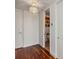 Hallway view into bathroom with wood floors, white walls, modern lighting and a decorative art piece at 150 E Robinson St # 801, Orlando, FL 32801