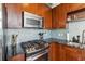 Close-up of the kitchen features stainless steel appliances, granite countertops, and tile backsplash at 150 E Robinson St # 801, Orlando, FL 32801