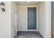Covered entryway featuring a gray front door, wall-mounted light fixture and brick pavers at 16419 Bird Of Paradise Ave, Clermont, FL 34714